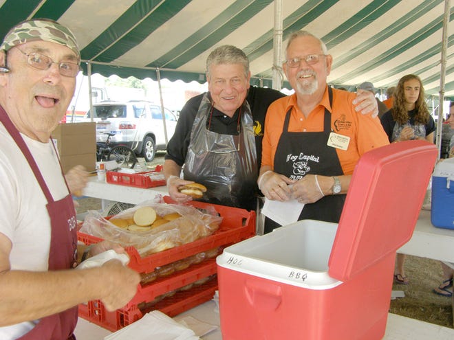 Here are some of the people those who have volunteered to assemble pork chop and pork patty sandwiches Hog Days weekend will be helping. Niles Reamer, right, vice chairman of the Hog Festival Committee, has been in charge of the tent for years with the help of a loyal but dwindling group of helpers like Bob Hardy, left. Chuck Deahl, center, is one of those volunteers who helped for years but he is now unable to do so due to his health. This photo was taken three years ago.