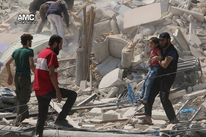 A Syrian man carries a girl away from the rubble of a destroyed building after barrel bombs were dropped on the Bab al-Nairab neighborhood in Aleppo, Syria, on Saturday. Syria activists said, at least 15 civilians have been killed when suspected government helicopters dropped barrel bombs on a wake for children killed in earlier airstrikes in rebel-held Aleppo.