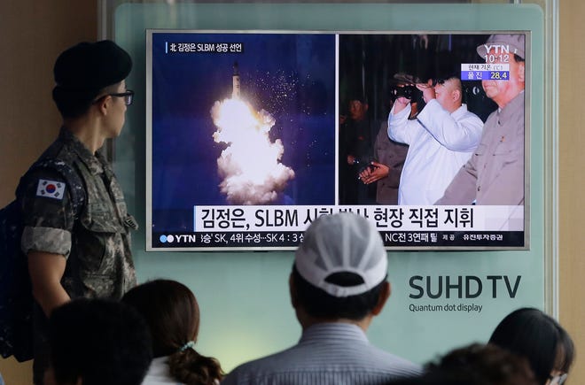 A South Korean army soldier watches a TV news program Thursday showing images published in North Korea's Rodong Sinmun newspaper of North Korea's ballistic missile believed to have been launched from underwater and North Korean leader Kim Jong-un, at Seoul Railway station in Seoul, South Korea. The UN Security Council is strongly condemning four North Korean ballistic missile launches in July and August, calling them "grave violations" of a ban on all ballistic missile activity. A press statement approved by all 15 members Friday night deplored the fact that the North's ballistic missile activities are contributing to its development of nuclear weapon delivery systems and increasing tensions.