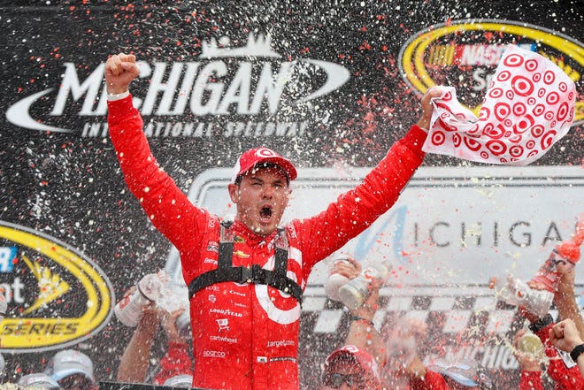 Kyle Larson celebrates after winning the NASCAR Sprint Cup Series auto race at Michigan International Speedway in Brooklyn, Mich., Sunday, Aug. 28, 2016. (AP Photo/Paul Sancya)