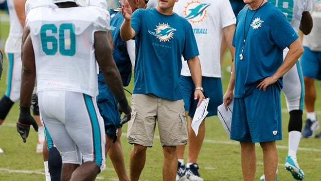 New Dolphins offensive coordinator Zac Taylor talks with ex-coach Joe Philbin. (Getty Images)