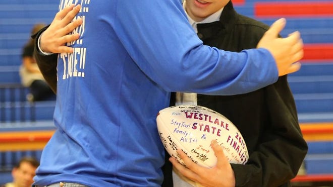 Westlake football player Elias Garcia, left, hugs Angel Ramirez after presenting him a signed football before the Chaparrals’ girls basketball game against Del Valle on Feb. 5, 2016 at Westlake High School.