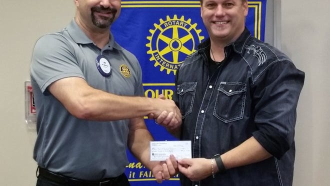 Rotary Club of Pflugerville president Jim McDonald, left, presents a donation of $900 to Tom Cottar, the Backpack Pfriends coordinator for First Baptist Church. The money will help fund Backpack Pfriends, which works to provide food to Pflugerville ISD students in need on weekends and holiday breaks. Contributed photo