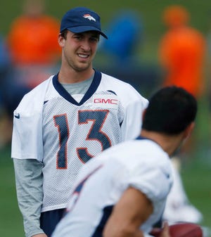 Denver Broncos quarterback Trevor Siemian, back, looks on as quarterback Mark Sanchez takes part in a drill during practice at the Broncos' headquarters on Monday in Englewood, Colo.