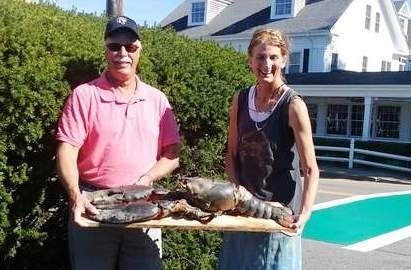 Ray Wilkes, left, and Jenny Bovey pose with the recently departed Big Lobi outside Bovey's Chatham store, Blue Water Fish Rubbings. Wilkes found the lobster Saturday afternoon, not far from where it had been released several days earlier. Photo courtesy of Ray Wilkes