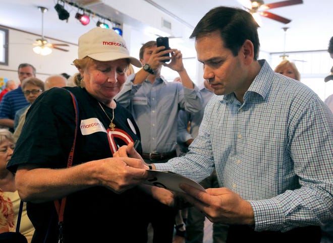 Ann Harris holds out a calendar for Republican Sen. Marco Rubio to sign Monday. The U.S. senator stopped in Lynn Haven to talk to voters during his last day of primary campaigning. He faces South Florida developer Carlos Beruff in today's primary.