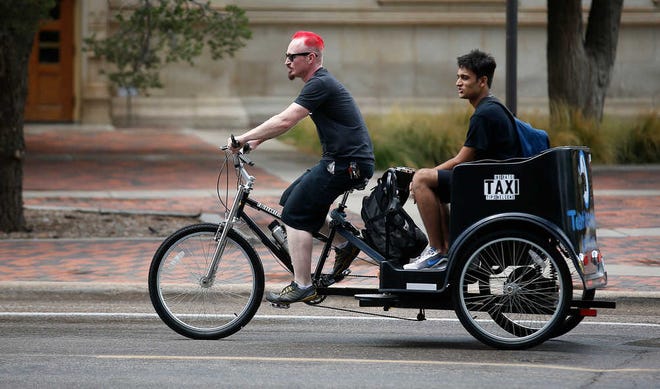 Benny Paul, a sophomore from Buffalo, N.Y., gives a ride to Shivam Patel, a freshman from Houston on Tuesday at Texas Tech. Paul has been giving free rides to students across campus since June.