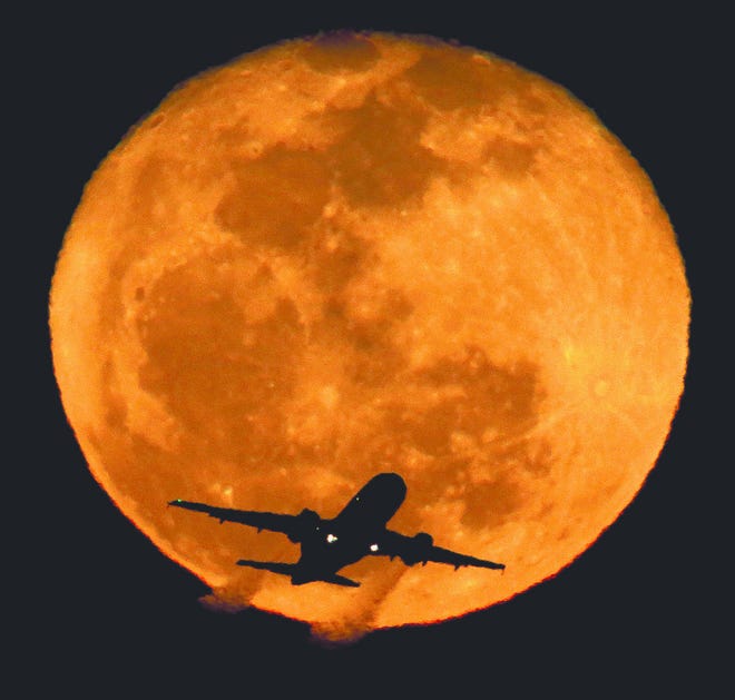 In this Tuesday, Feb. 26, 2013, file photo, a waning moon rises in the distance as a passenger jet takes off at Phoenix's Sky Harbor Airport. A handful of U.S. pilots each year fail random sobriety tests. Those who fail can fly again if they prove rehabilitation. (AP Photo/Charlie Riedel, File)