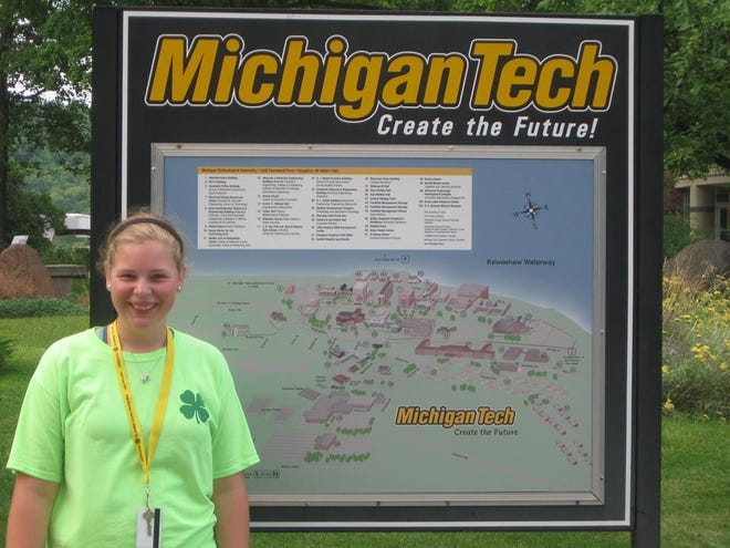 Sadie Loveless stands in front of a sign at Michigan Tech University where she attended a summer program.