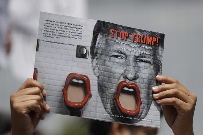 A demonstrator protesting Donald Trump's meeting with the Mexican president holds up a book jacket with the title; "Stop Trump!" during a morning protest at the Angel of Independence Monument that drew just a handful of people, in Mexico City, Wednesday. After Trump's meeting with their president, Mexicans took harsh aim on social media. REBECCA BLACKWELL/AP PHOTO