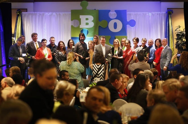 Winners of the Gainesville Area Chamber of Commerce's 2015 business of the year awards gather on stage for a group photo. (File)