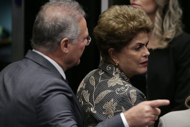 Brazil's Senate leader Renan Calheiros points to an exit as suspended President Dilma Rousseff looks to leave Senate chambers after addressing the lawmakers, at the start of a short recess of her own impeachment trial, in Brasilia, Brazil, Monday. (AP Photo/Eraldo Peres)