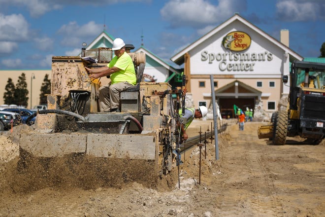 Workers clear dirt on the property around what will be the parking lot for the new Bass Pro Shops in Celebration Pointe. Rob C. Witzel/Special to the Guardian