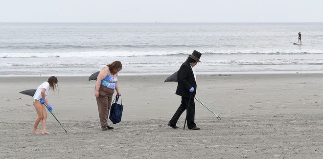 John Brennan of Newport and his wife, Michelle and daughter, Bailey, 9, pick up trash at Easton's Beach during the Clean Ocean Access Jaws for a Cause event in Newport in 2016. Photo by Dave Hansen