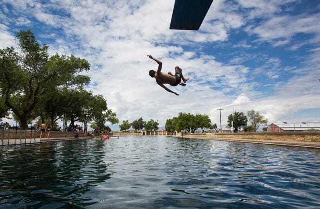 ADVANCE FOR WEEKEND EDITIONS AUG. 27-28 - In this Aug. 18, 2016 photo, a boy jumps off the diving board into 30 feet of water at the natural spring pool at the Balmoreah State Park in Balmoreah, Texas. The rise of fracking nearby the town has some community members worried about their drinking water and natural springs, which serve as a popular tourism destination helping drive the town's economy. (Brittany Greeson/The San Antonio Express-News via AP)