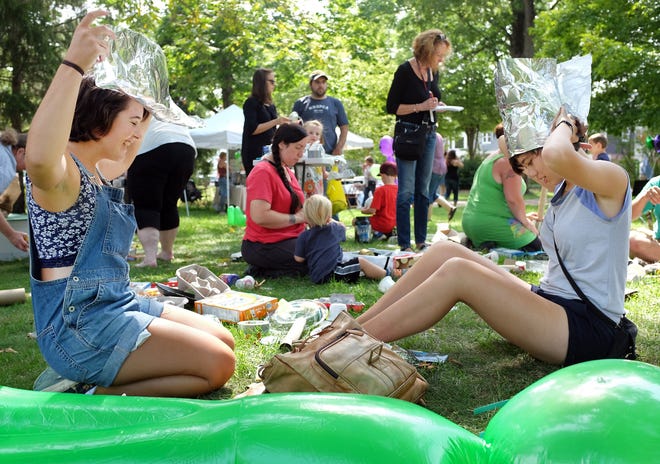 Maria Heeter, left, of Dover and Cora Payne of Exeter construct tin foil hats at "the crash site" at Town Park during the Exeter Area Kiwanis Club's annual UFO Festival on Saturday. Photo by Ioanna Raptis/Seacoastonline