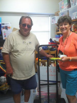 Mike Chuven, left, delivered the books to After School Program Coordinator Kerri Markey.