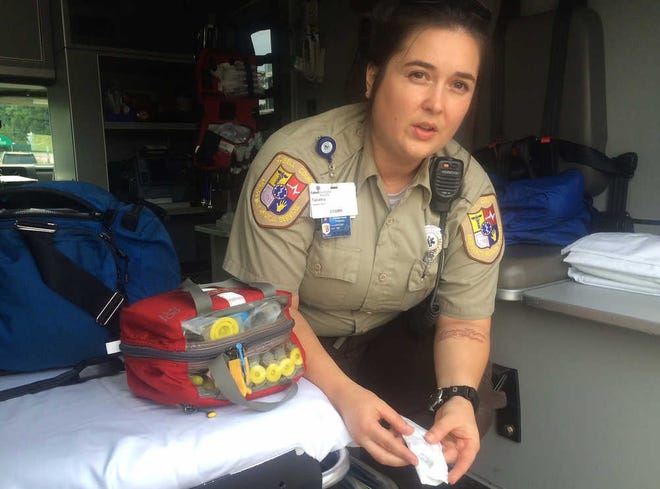 In this Aug. 28, 2016 photo, Cabell County EMT Tabitha Perez demonstrates how medics administer naloxone to overdosing patients, in Huntington, W.Va. On Aug. 15, 28 people overdosed in Huntington and 26 survived. Without the life-saving drug, authorities suspect the death toll would have been much higher. The laced heroin was so potent, the typical dose failed to revive many of them. They used two, sometimes three doses to bring them back to life. (AP Photo/Claire Galofaro)