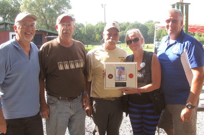 The winning team at the Mid-Hudson Sporting Clays Shoot — Roy Zucca, Fred Stokes, Jim DeMato and Mike Keglovitz — are presented with a plaque by Cheryl Hodges in memory of her son, Marine Sgt. Christopher Hrbek, who was killed in Afghanistan. A scholarship has been created in his honor. PHOTO PROVIDED