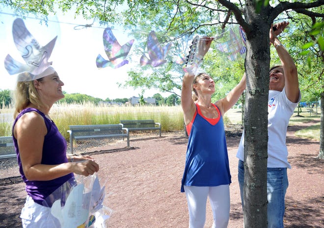 From left, Nicole Augustine, Tara Bane and Judi Reiss hang 4,000 paper doves — to represent those who died in the attacks on the World Trade Center on Sept. 11, 2001 and first responders who have died since — at the Garden of Reflection in Lower Makefield on Wednesday, September 7, 2016.