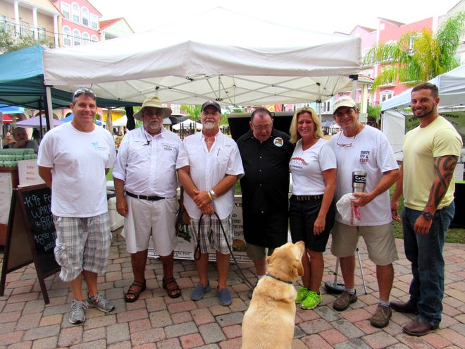 From left, Scott Campion, president of the European Village Commercial Association; Gourmet Market manager Michael Cosmo, K9's for Warriors volunteer John Whelan, The Fresh from Florida Meat Company owner Jan Costa, Heather Thompson, Dennis Cone and United States Army veteran William Grosse at the Labor Day weekend barbecue event at European Village. NEWS-TRIBUNE/DANIELLE ANDERSON