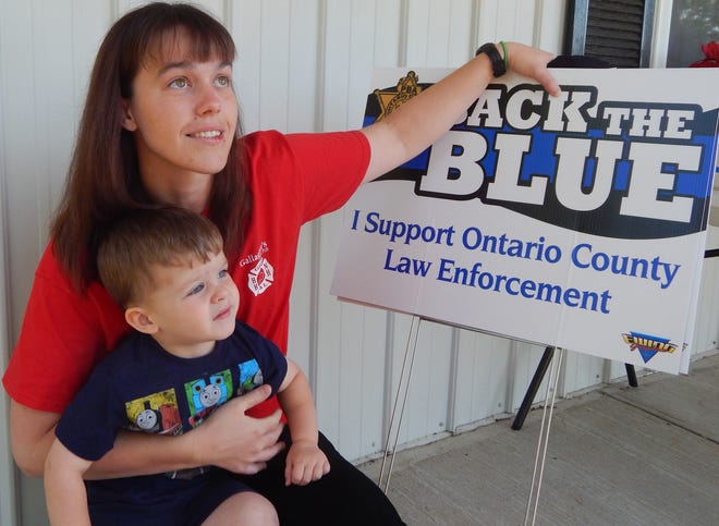 Jaime Haag and her son, of Geneva, show support for local law enforcement by purchasing a few yard signs that "Back the Blue." The money raised through the yard signs, T-shirts and stickers will go toward a fund supporting Ontario County law enforcement. AARON CURTIS/MESSENGER POST MEDIA