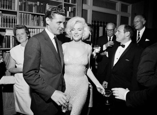 In this May 19, 1962 photo provided by the John F. Kennedy Presidential Library and Museum, actress Marilyn Monroe wears the iconic gown that she wore while singing "Happy Birthday" to President John F. Kennedy at Madison Square Garden, during a reception in New York City. Standing next to Monroe is Steve Smith, President Kennedy's brother-in-law. Julien's Auctions will offer Monroe's gown at auction in Los Angeles on Nov. 17, 2016. (Cecil Stoughton/White House Photographs, John F. Kennedy Presidential Library and Museum via AP)