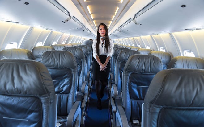 Flight attendant Andie Jimenez greets the media during a tour of Elite Airways' 70-seat CRJ-700 jet at Sarasota-Bradenton International Airport on Wednesday. The jet will be used for nonstop flights from SRQ to Portland, Maine, starting Nov. 17. HERALD-TRIBUNE STAFF PHOTO / DAN WAGNER