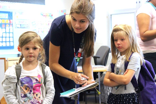 On her first day as a teacher on Tuesday, Brenna Potter smoothly handled several issues in her Wall School classroom, including comforting kindergartners Ava Miner and Analeah Bell.
