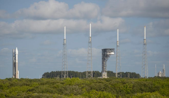 In this Wednesday, Sept. 7, 2016 photo, a United Launch Alliance Atlas V rocket, left, carrying NASA's OSIRIS-REx spacecraft, sits at its launchpad at Cape Canaveral Air Force Station in Florida. The mission, scheduled to launch on Thursday, Sept. 8, is the first U.S. attempt to reach an asteroid return a sample to Earth for study. (NASA/Joel Kowsky via AP)