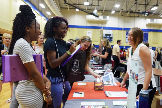 St. Augustine High School junior Lakevia Clark, left, and Pedro Menendez High School junior Shianne Thompson speak with recruiter Laura Blanchard from the Fashion Institute of Design and Merchandising in Los Angeles during the St. Johns County School District's annual College and Career Night on Wednesday at Pedro Menendez High School.