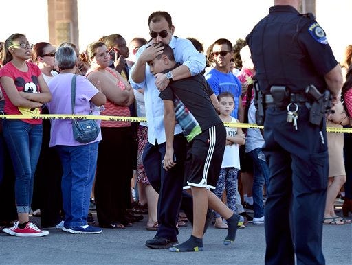 A parent hugs his child after being released from Walter Johnson Junior High School Wednesday, Sept. 7, 2016, in Las Vegas. Hundreds of anxious parents staked out a Las Vegas middle school after mercury was found and federal officials kept more than a thousand students for up to 17 hours to screen them for exposure to the neurotoxin.. (David Becker/Las Vegas Review-Journal via AP)