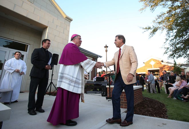 Bishop Robert Baker, left, of the Catholic Diocese of Birmingham, shakes hands with Alabama coach Nick Saban as Saban arrives for the blessing ceremony of the new Saban Catholic Student Center at St. Francis in Tuscaloosa on Friday, Sept. 9. Staff Photo/Erin Nelson