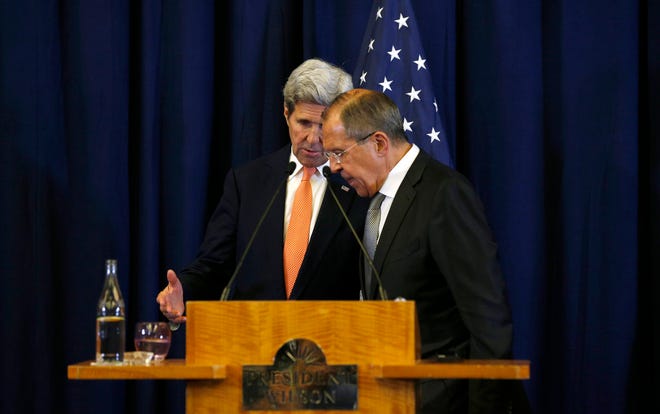 U.S. Secretary of State John Kerry, left, and Russian Foreign Minister Sergei Lavrov confer at each other at the conclusion of a joint press conference following their meeting to discuss the crisis in Syria, in Geneva, Switzerland, Friday, Sept. 9, 2016. (Kevin Lamarque/Pool Photo via AP)