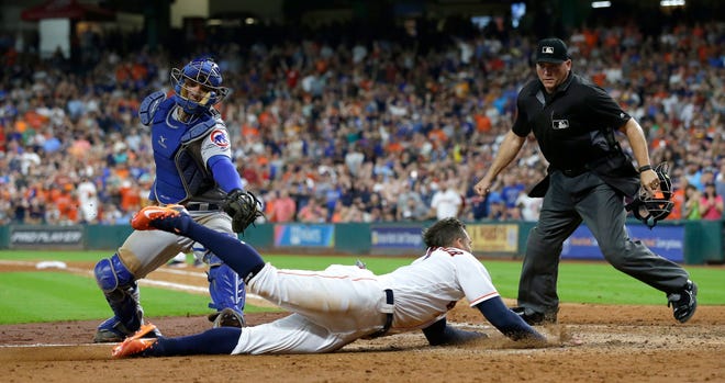 Houston Astros' George Springer, center, is tagged out by Chicago Cubs catcher Willson Contreras, left, while trying to score during the seventh inning of a baseball game Saturday, Sept. 10, 2016, in Houston. (AP Photo/David J. Phillip)