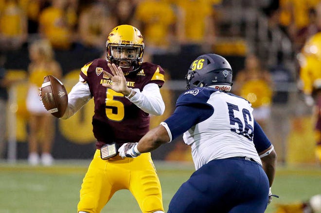 Arizona State's Manny Wilkins (5) tries to avoid the pass rush of Northern Arizona's Deon Young (56) during the second half of an NCAA college football game Saturday, Sept. 3, 2016, in Tempe, Ariz. Wilkins was sacked on the play, but Arizona State defeated Northern Arizona 44-13. (AP Photo/Ross D. Franklin)