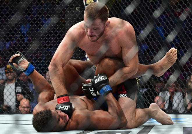 Stipe Miocic, top, punches Alistair Overeem, from the Netherlands, during a heavyweight title bout at UFC 203 on Saturday in Cleveland. Associated Press/David Dermer