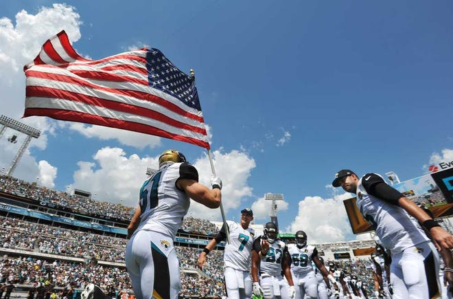 Will.Dickey@jacksonville.com--09/11/16--Jacksonville Jaguars middle linebacker Paul Posluszny (51) carries the flag onto the field during player introductions at the start of the game against Green Bay Sunday, September 11, 2016 at EverBank Field in Jacksonville, Florida. (The Florida Times-Union, Will Dickey)