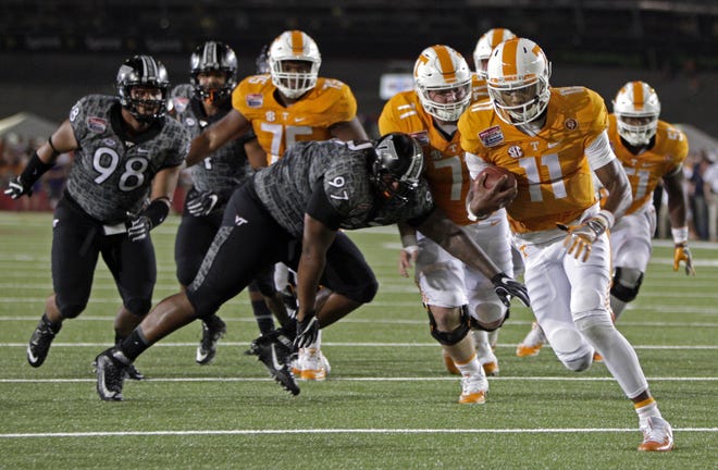 Tennessee quarterback Joshua Dobbs (11) for a touchdown while being chased by Virginia Tech defensive tackle Tim Settle (97) during an NCAA college football game at Bristol Motor Speedway on Saturday, Sept. 10, 2016, in Bristol, Tenn. (AP Photo/Wade Payne)