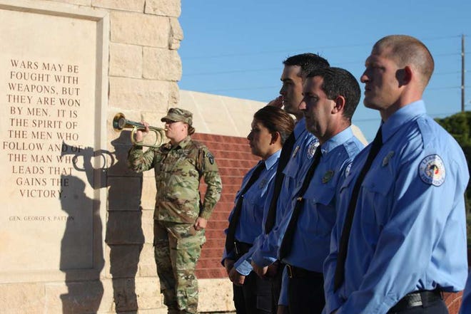 Corporal Ashlie Glover, of the Texas Army National Guard in Lubbock, plays "Taps" as first responders stand silently during a ceremony Sunday morning at the Veterans War Memorial in Lubbock. The ceremony remembered and honored those who lost their live during the 9/11 terrorist attacks. (Sarah Rafique/A-J Media)