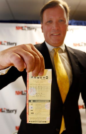 Charlie McIntyre, executive director of the New Hampshire Lottery Commission, holds the winning $487 million Powerball ticket from the July 30 drawing during a news conference Monday Sept. 12, 2016 in Concord, N.H. The lottery announced a New Hampshire family has come forward to claim the winning money but wishes to remain anonymous. (AP Photo/Jim Cole)