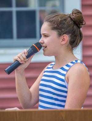 Alayna Rooney sings the Star Spangled Banner. PHOTO BY ALAN BELANICH