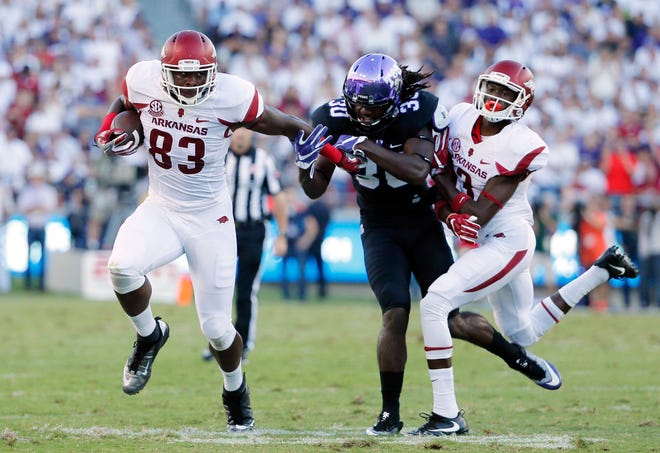 Arkansas tight end Jeremy Sprinkle (83) fights off a tackle attempt by TCU safety Denzel Johnson with help from wide receiver Dominique Reed, right, during the Razorbacks’ 41-38 doubleovertime victory over then-No. 15 TCU on Saturday in Fort Worth, Texas.