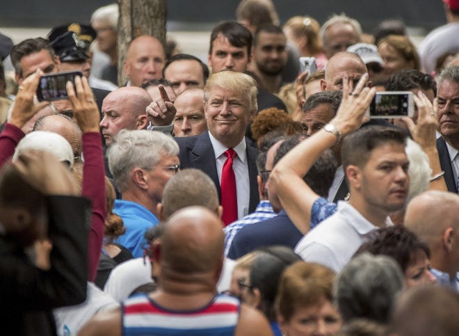 Donald Trump, center, greets members of the audience as he attends Sunday's ceremony at the National September 11 Memorial in New York.