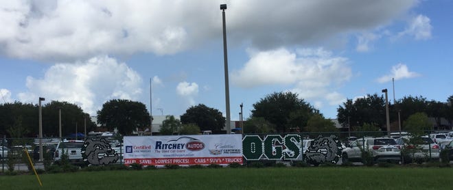 A Ritchey Autos banner partially obscures the FPC Bulldogs sign on Saturday at Flagler Palm Coast High School where Ritchey Autos set up a temporary car sales lot for a promotion called "Wheels and Keels." NEWS-JOURNAL/FRANK FERNANDEZ