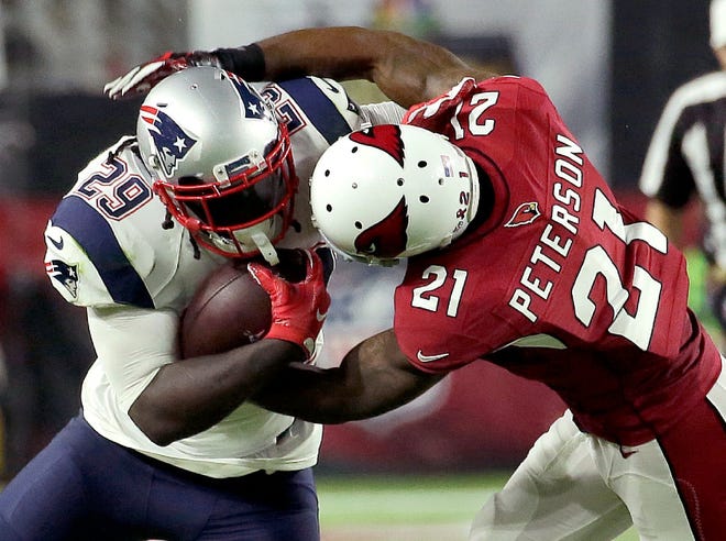 Patriots running back LeGarrette Blount, who had 70 yards rushing and a touchdown, runs over Cardinals cornerback Patrick Peterson on Sunday.