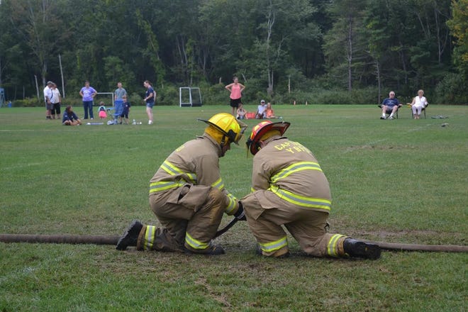 Members of the York Beach Fire Department attach hoses in quick succession in wet muster event at York High School on Sunday.

Photo by David Ramsay