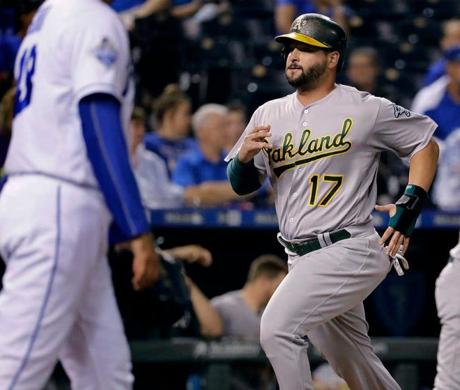 Oakland Athletics' Yonder Alonso runs home to score on a single by Marcus Semien during the eighth inning of a baseball game against the Kansas City Royals on Tuesday, Sept. 13, 2016, in Kansas City, Mo. (AP Photo/Charlie Riedel)