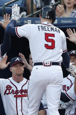 Atlanta's Freddie Freeman is greeted by teammates after hitting a two-run home run during Tuesday's game against Miami. John Bazemore/The Associated Press