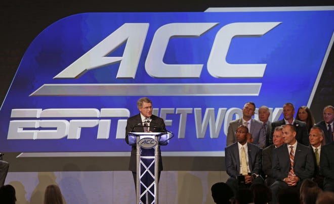 FILE - In this July 21, 2016, file photo, ACC Commissioner John Swofford, center, announces an ACC/ESPN Network during a news conference at the Atlantic Coast Conference Football Kickoff in Charlotte, N.C. The Atlantic Coast ConferenceþÄôs dedicated television channel is coming in three years. The planning process is already underway. (AP Photo/Chuck Burton, File)